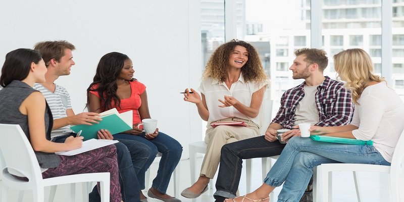Smiling therapist speaking to a rehab group